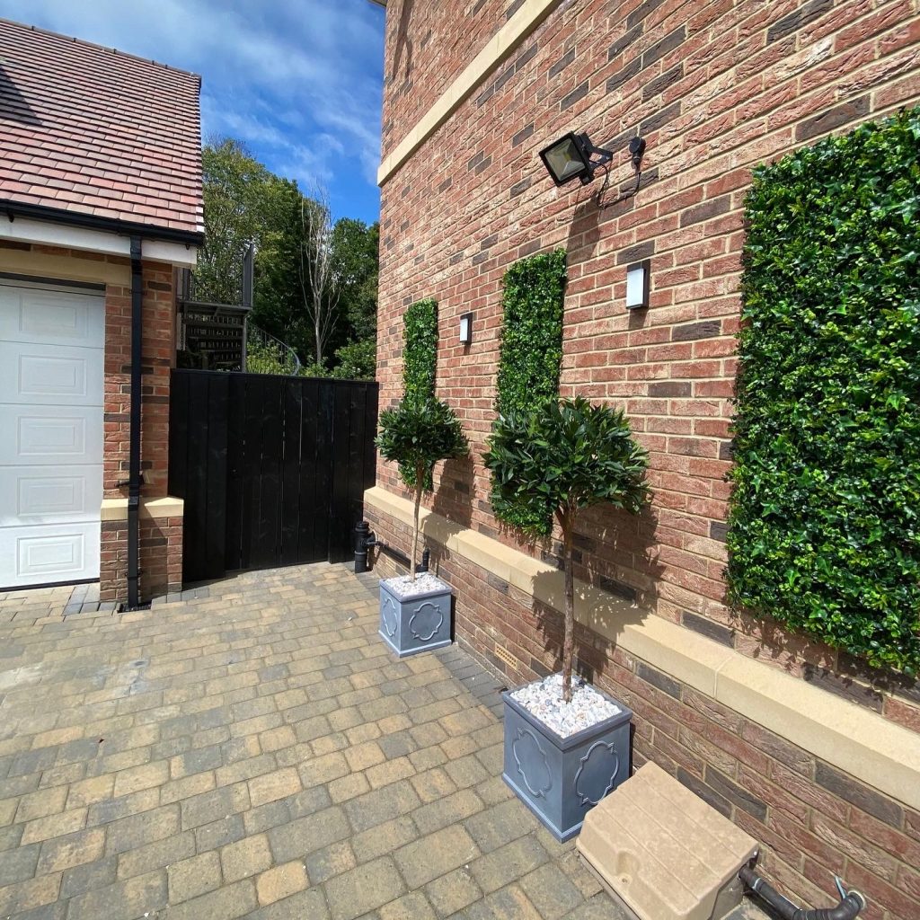 fire retardant artificial foliage tiles secured onto the side of a building