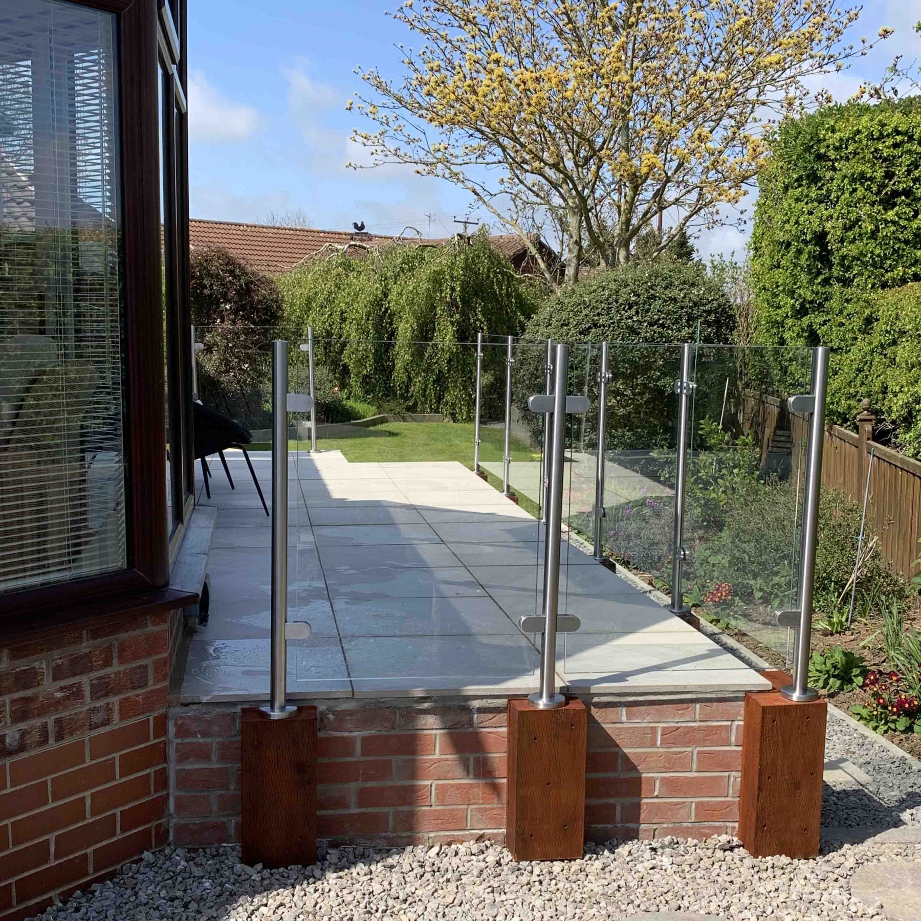 semi-frameless-balustrade-installed on sleepers edging a paved patio