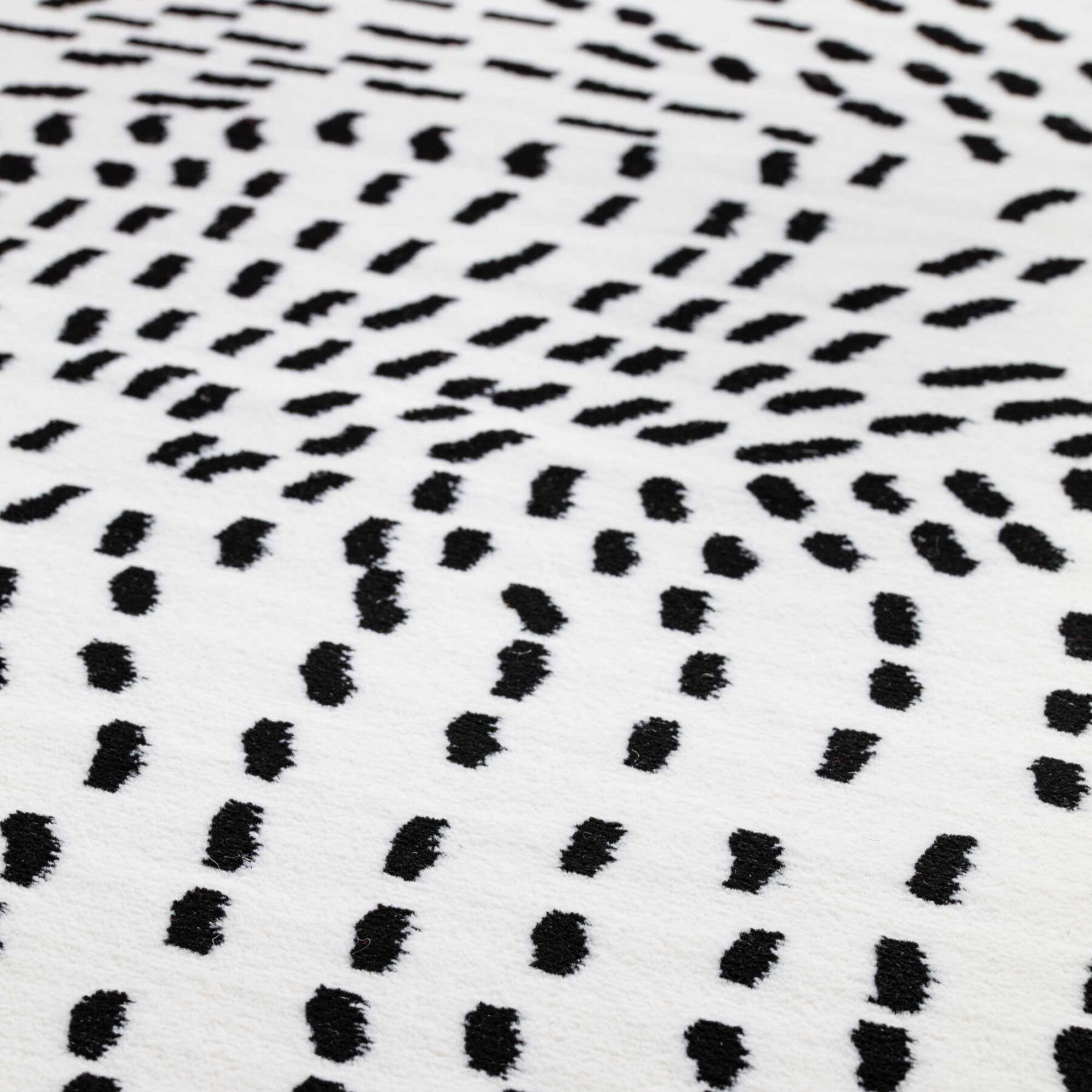 pattern of Tiago indoor rug spotted design white background with black spots